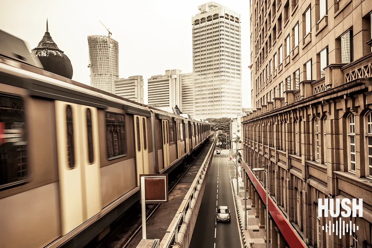 Elevated train passing between apartment buildings in New York, a source of elevated train noise